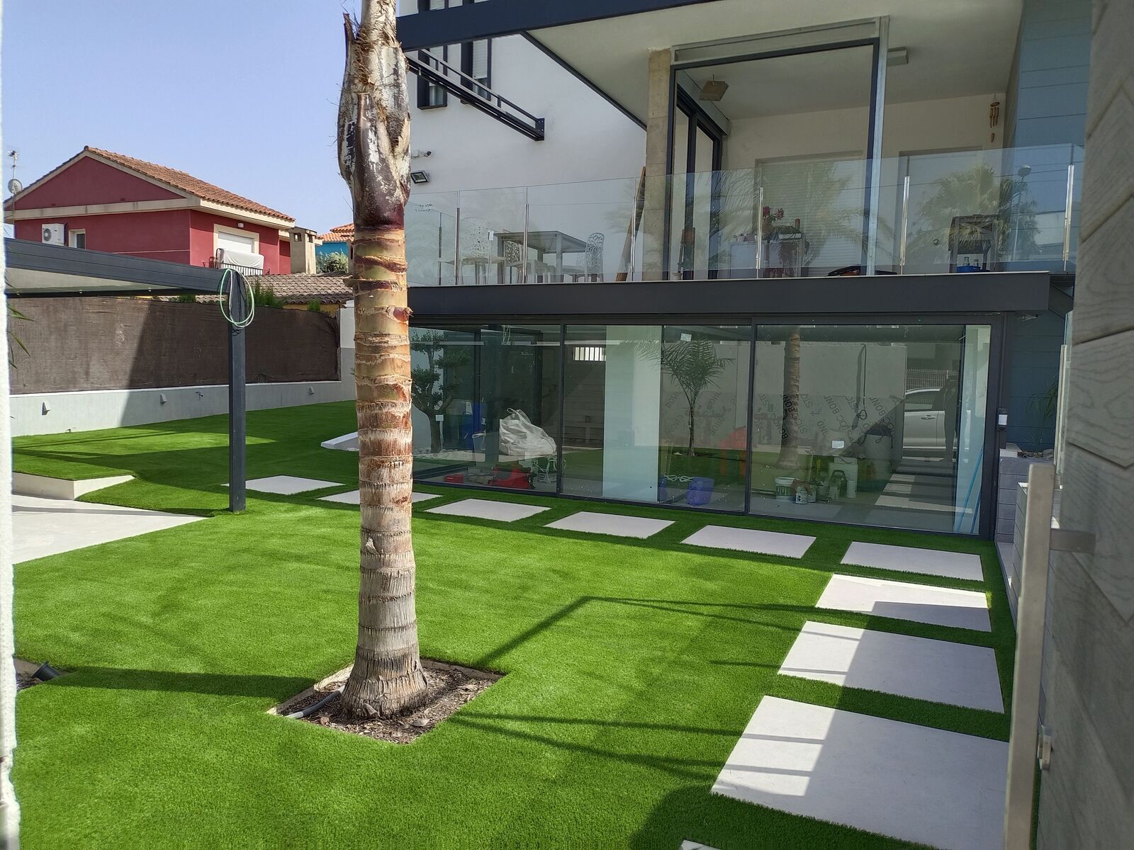 Villa moderna con césped y palmera