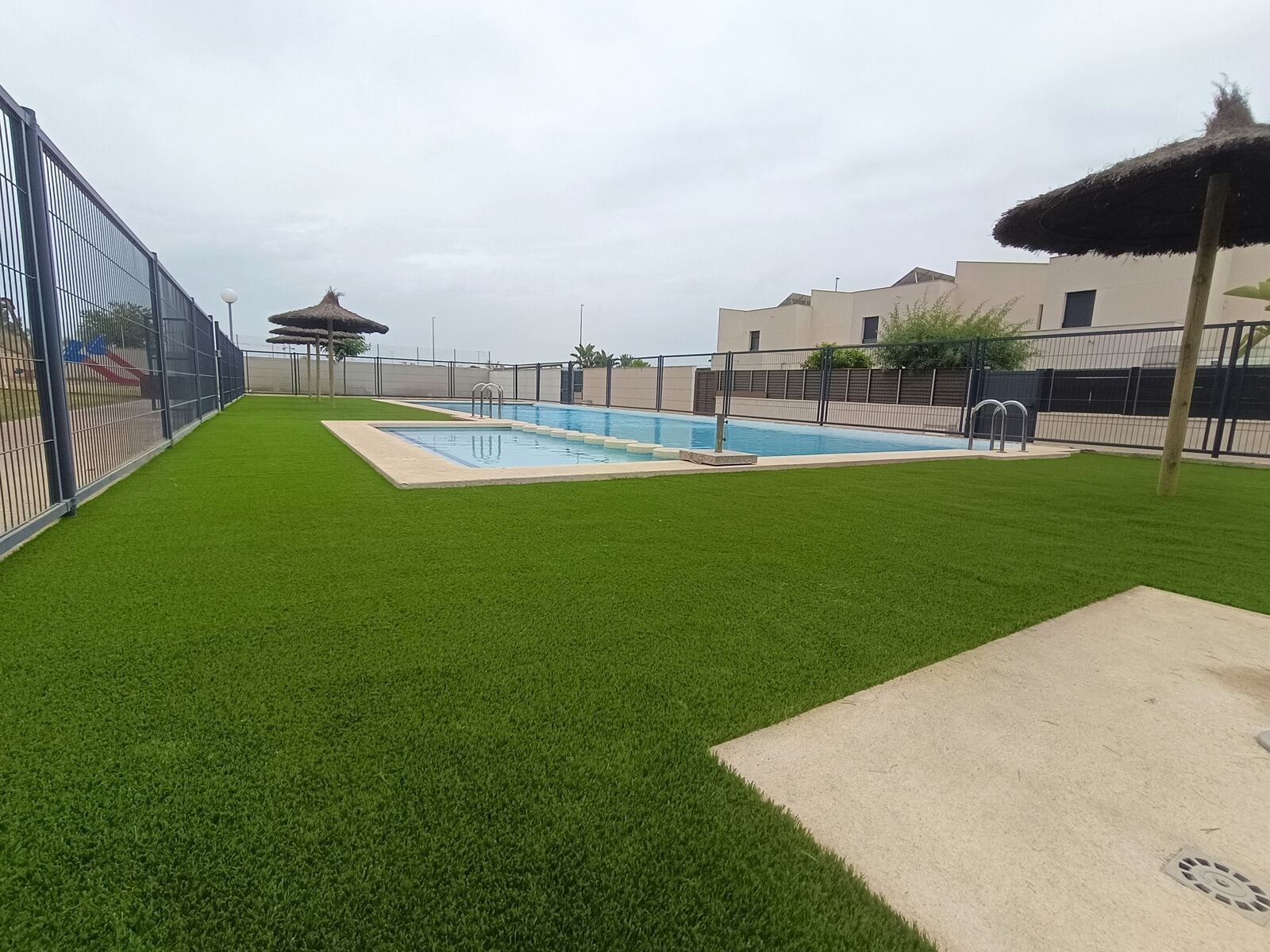 Piscina comunitaria con césped